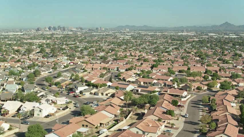 Aerial view of a suburban neighborhood in phoenix, arizona, with city skyline