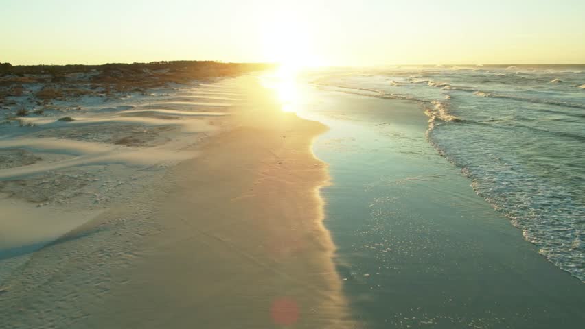 The sun rises over the sandy beach in gulf shores, alabama