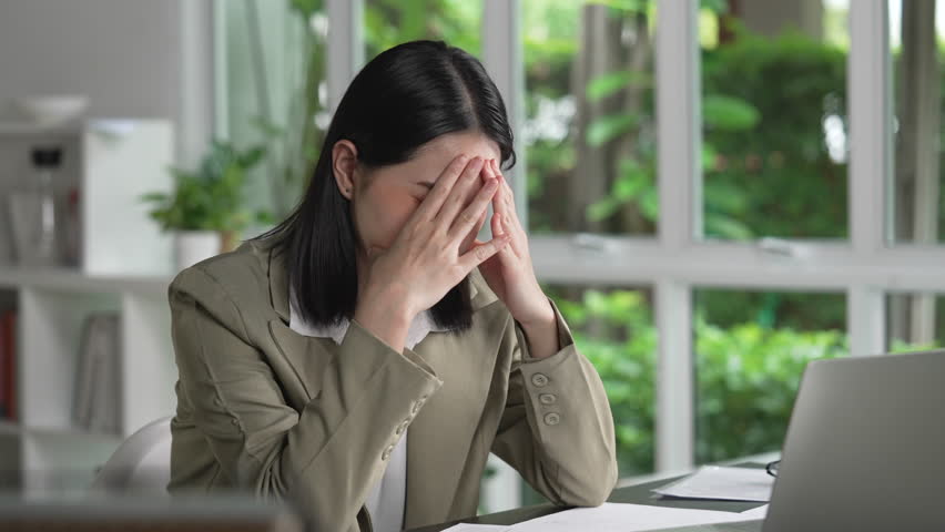Young Asian Businesswoman looking stressed from work, Tired young businesswoman working at office