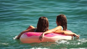 Summer Vacation Woman floats on an inflatable donut mattress, a water toy swim ring. Positive happy woman relaxing and enjoying family summer travel holidays vacation on the sea. Slow motion - Powered by Shutterstock - Get 15% off with code: PIKWIZARD15