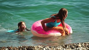 Summer Vacation Woman floats on an inflatable donut mattress, a water toy swim ring. Positive happy woman relaxing and enjoying family summer travel holidays vacation on the sea. Slow motion - Powered by Shutterstock - Get 15% off with code: PIKWIZARD15