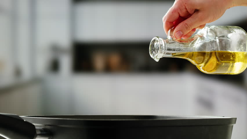 Pouring olive linen oil sunflower in different dishes close-up. Using in cooking for frying foods or as a salad dressing omega 3. Olive oil is popular supplement for meals and salads. 