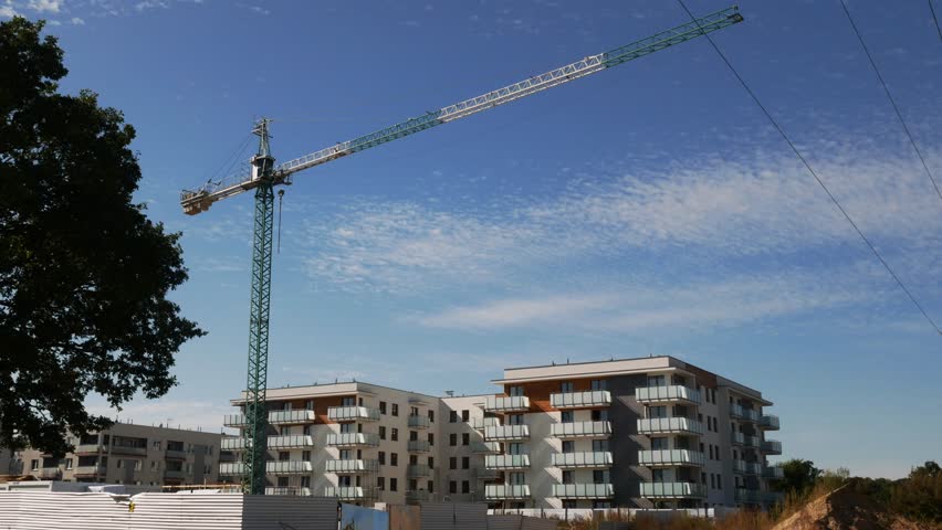 Modern residential complex with crane and ongoing construction, urban cityscape, new home development, real estate footage
