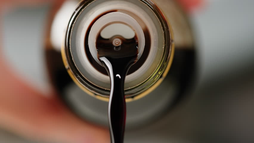 Asian Japanese soy sauce, Dark brown soy sauce pouring down into the glass bowl close up
