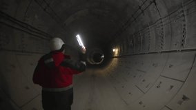 Underground corridor becomes alive with focused light of lamp. Worker silhouette crosses dusty air while beam cuts through darkness - Powered by Shutterstock - Get 15% off with code: PIKWIZARD15
