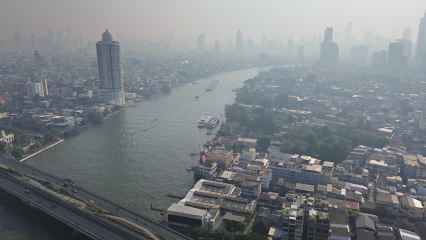 Aerial view of skyscrapers in Bangkok city and bridge over Chao Phraya River, 4k
