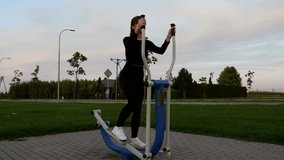 Young woman exercising on outdoor elliptical machine in public park. Daily fitness workout for healthy lifestyle. Cardio training for strength and endurance. - Powered by Shutterstock - Get 15% off with code: PIKWIZARD15