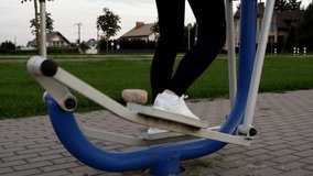 : Young Woman Exercising on Elliptical Machine Outdoors in Evening - Powered by Shutterstock - Get 15% off with code: PIKWIZARD15