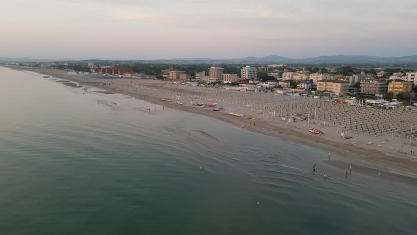 Aerial drone view of sunrise over Rimini beach and city on the Adriatic coast, Italy