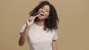 Playful African Woman Singing,Dancing With HairBrush Instead Microphone On Beige - Powered by Shutterstock - Get 15% off with code: PIKWIZARD15