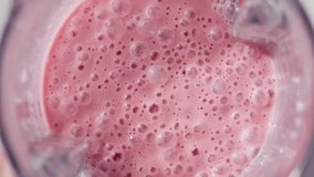Strawberry and banana pink milkshake blended in blender with splashes. top view. slow motion. Healthy protein smoothie drink concept , food closeup. Protein powder falling in smoothie from spoon - Powered by Shutterstock - Get 15% off with code: PIKWIZARD15