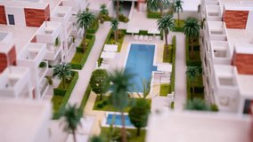 Realistic architectural scale model portraying  modern residential area featuring apartment complexes, roads, tiny vehicles, and lush parks, highlighting urban design and property development - Powered by Shutterstock - Get 15% off with code: PIKWIZARD15
