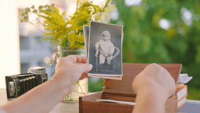 Hands holding vintage black and white photo baby family archive near wooden box and flowers, nostalgia ancestry genealogy memory history, Tracing family roots through images, journey into ancestry - Powered by Shutterstock - Get 15% off with code: PIKWIZARD15