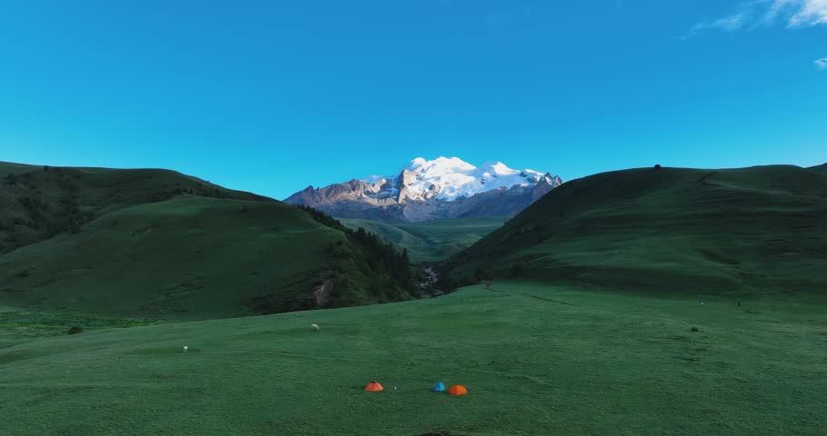 Aerial footage of have a camp with the beautiful high altitude snow capped mountains and grassland landscape in China