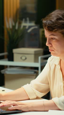 Vertical Video General manager in a dark office at midnight struggles to stay awake after an intense workload, dealing with anxiety due to work tension and fatigue. Mental haze and workplace