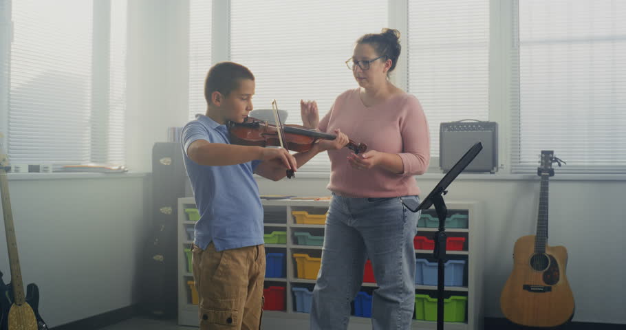 Talented Boy Playing Violin During Music Lesson in Elementary School, Rehearsing Before Musical Performance. Teacher Supporting and Teaching Future Musician. Musical Education, Violin Practice Class.