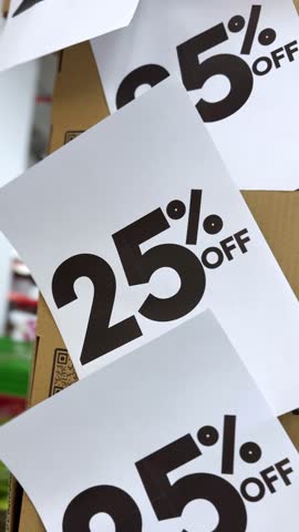 Vertical footage of multiple 25% OFF discount signs on cardboard box. Perfect for e-commerce, social media ads, retail sales, Black Friday, Cyber Monday, clearance and seasonal promotions.