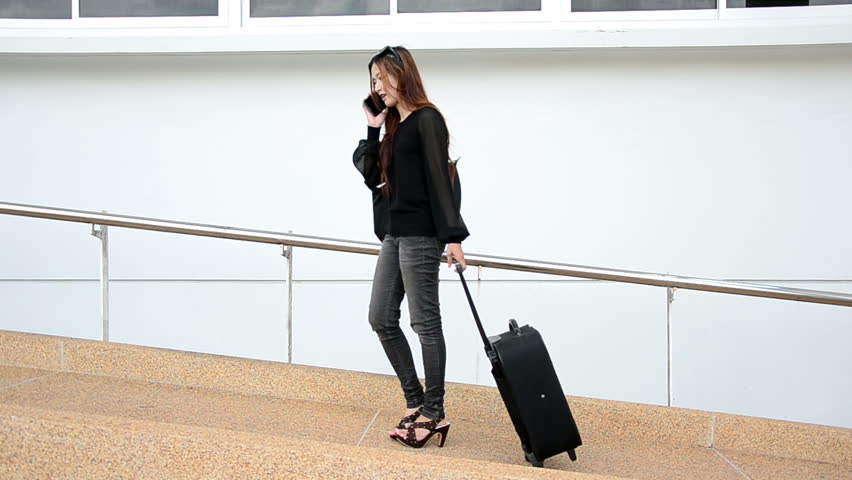 Young business woman on the phone and going to flight