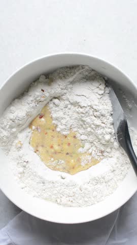 overhead view of savory biscotti dough being mixed in a bowl, top view of savory cookie dough in a mixing bowl