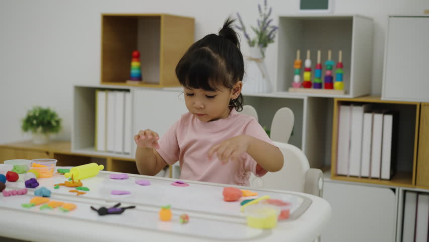 toddler girl with sculpting from plasticine at home