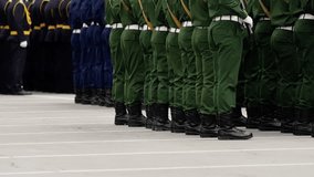 Disciplined military formation with uniformed personnel in green and dark dress standing in precise ranks on a marked concrete parade ground during a ceremony, boots aligned. - Powered by Shutterstock - Get 15% off with code: PIKWIZARD15