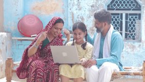Happy rural indian family using laptop. Parents with child daughter learning computer modern technology at home. Girl education. India. 4k - Powered by Shutterstock - Get 15% off with code: PIKWIZARD15