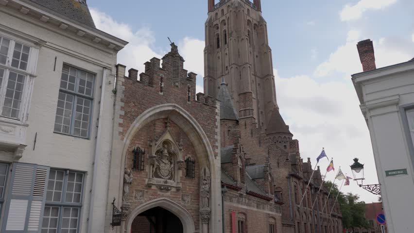 Gothic entrance and towering Church of Our Lady dominate the historic cityscape of Bruges