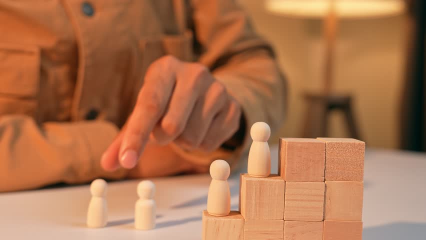 An HR places male and female wooden figures on the same level, symbolizing gender equality in society and the workplace, as well as fair opportunities and inclusive leadership for all individuals.
