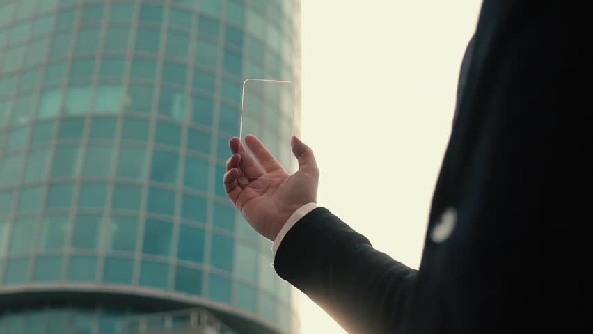 Man holding a futuristic holographic phone with digital interface, symbolizing innovation, modern communication, virtual reality, and advanced technology.