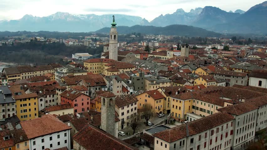 Italy (Veneto province). Belluno, beautiful city located in the heart of the Valbelluna valley, surrounded by the majestic peaks of the Dolomites mountains, aerial drone 4k hd video