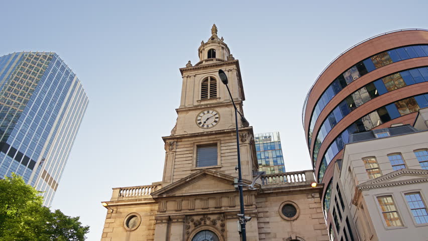 St. Botolph-without-Bishopsgate church standing prominently at the edge of Liverpool Street, framed by gleaming glass towers in London, England