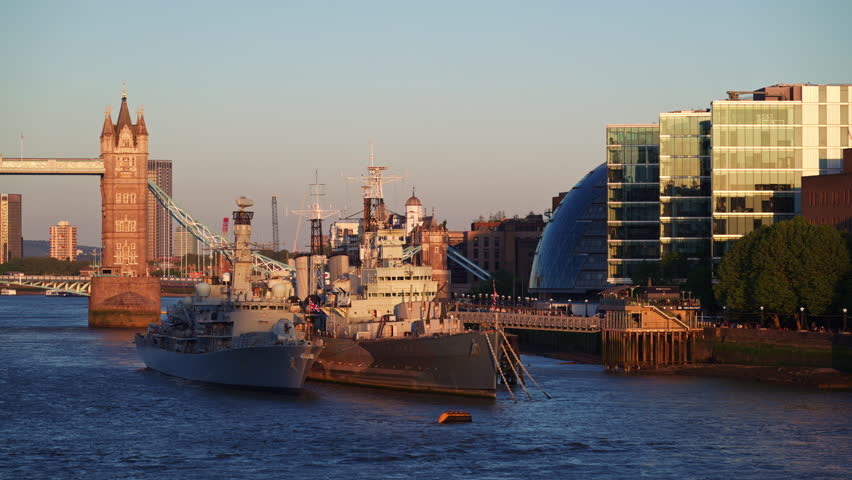 Beautiful sunset over the Thames River featuring Tower Bridge and the HMS Belfast warship, London, England