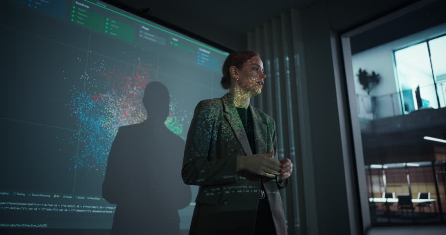 Female IT Professional Delivering a Keynote Presentation on Artificial Intelligence in a Modern Conference Room. She Stands in Front of a Screen with Machine Learning Charts and Digital Data Visuals