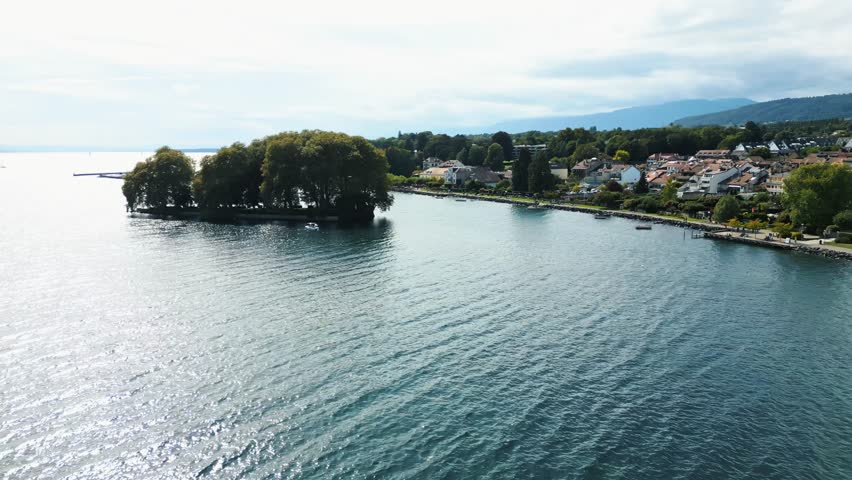 Aerial view of Île de la Harpe island with lush trees, alongside Rolle