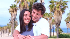 Happy young couple outdoors with palm trees, smiling and posing for selfie, lifestyle, romance, leisure, modern love, summer fun, digital connection, online sharing, social media, cheerful emotions - Powered by Shutterstock - Get 15% off with code: PIKWIZARD15