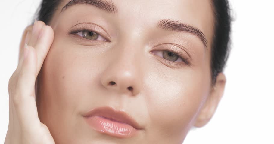 Delicate model touches her lips and cheek in closeup, highlighting dewy, glowing skin. Perfect for skincare promos, anti-aging beauty, wellness lifestyle, and refined cosmetic branding.