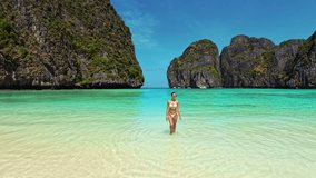 Model in white bikini walks out of turquoise water onto beach at Maya Bay, Thailand. Perfect for travel, summer, fashion and influencer campaigns. High quality tropical lifestyle footage. - Powered by Shutterstock - Get 15% off with code: PIKWIZARD15