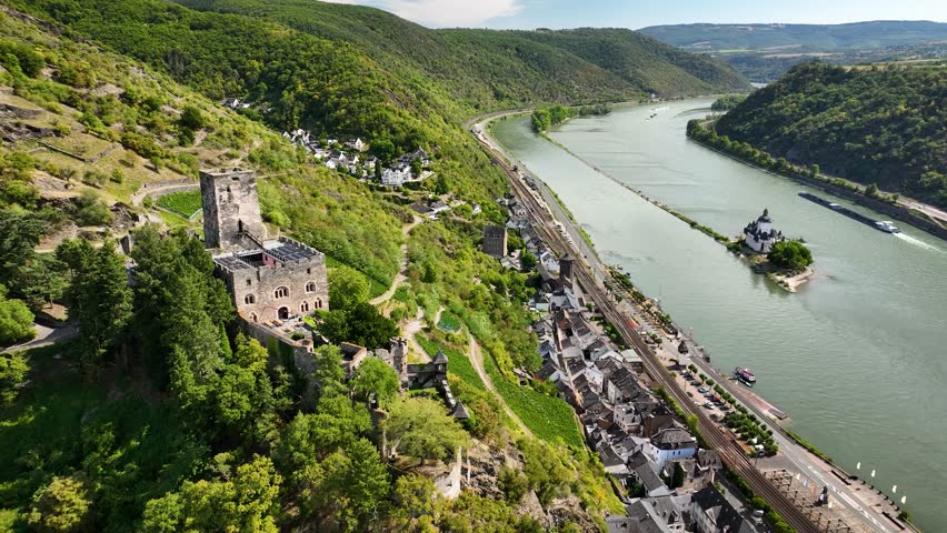  Aerial footage over the Rhine Valley with medieval hillside castle Gutenfels, vineyards, town of Kaub and Pfalzgrafenstein Castle located on a small island in the river.