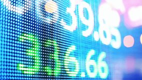 A close up of a digital stock market ticker board with fluctuating numbers. This financial data display represents trading, investment, and the global economy's volatility. - Powered by Shutterstock - Get 15% off with code: PIKWIZARD15