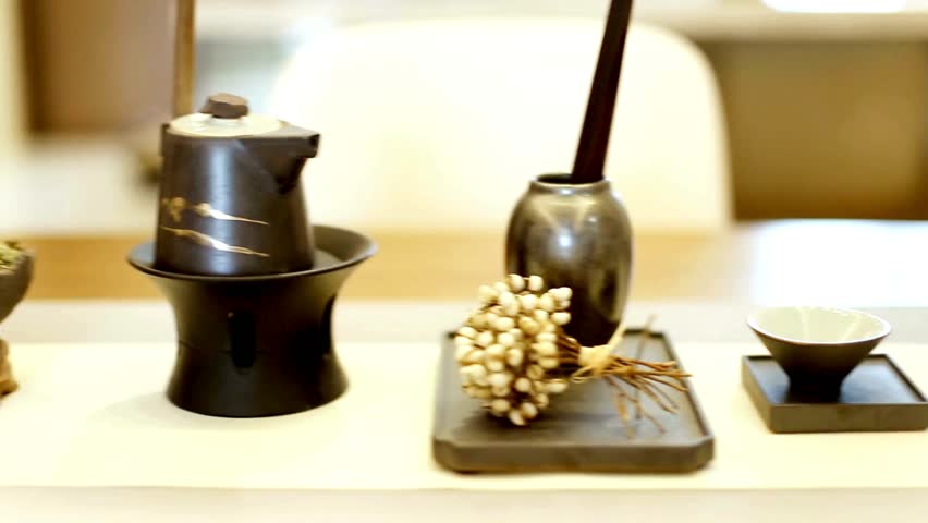 A slow pan across a minimalist table setting with a traditional Asian ceramic tea set. This tranquil still life evokes feelings of Zen, peace, and mindfulness.