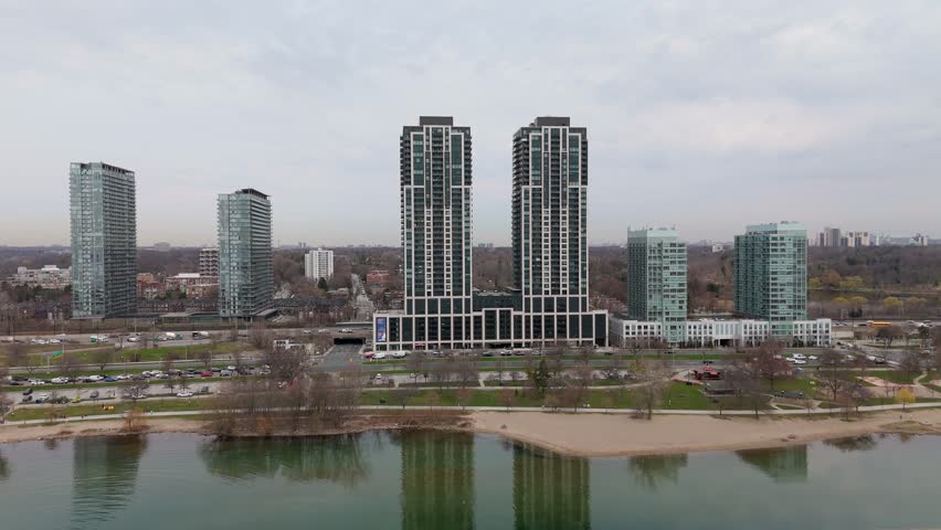 Receding drone shot over Lake Ontario revealing Parklawn condo towers and traffic