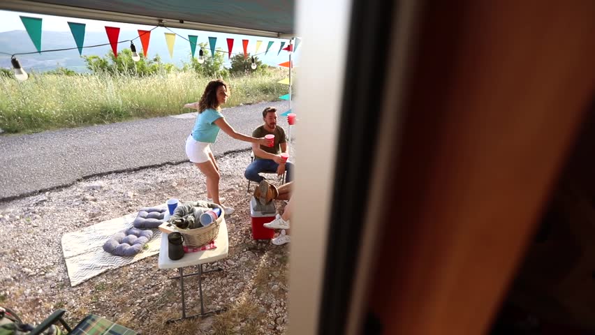 young group of people having fun in nature on camping dancing singing