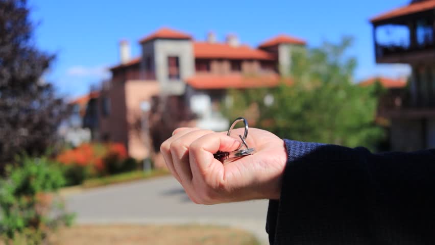 The owner of an apartment or house hands over the keys to a new tenant or buyer. A profitable house sale deal. A silver house-shaped keychain. Selling and buying a house. - Powered by Shutterstock - Get 15% off with code: PIKWIZARD15