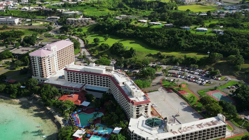 Picturesque aerial overview of Guam Hilton Resort Hotel and Spa along scenic coastal waters in a tropical island.