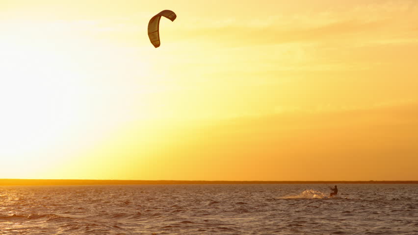 Kitesurfer jumping high above sea waves in golden sunset light symbol of extreme sport lifestyle freedom inspiration tropical holiday exotic paradise commercial travel footage summer vibes happiness