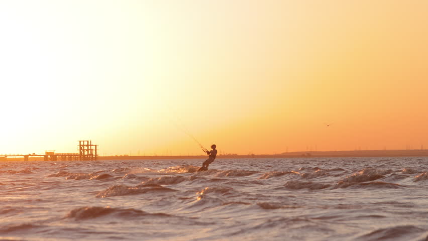 Kitesurfer flying over waves tropical paradise golden sunset water spray symbol of freedom happiness adventure lifestyle commercial summer vibes exotic holiday vacation travel destination inspiration