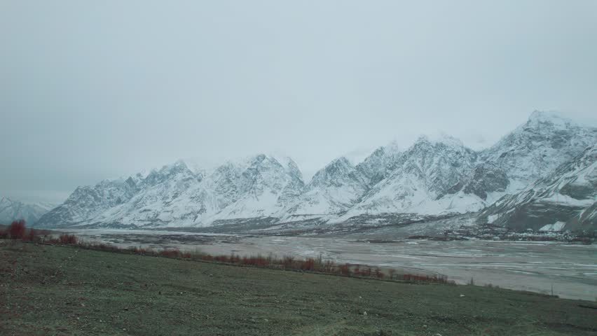 Beautiful drone view of snow capped mountains and highway in Gilgit Baltistan, Pakistan. Beautiful mountains, sun rising, cloudy weather, spa, nature, travelling, northern area of Pakistan, tourism. 