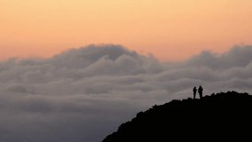 Two hikers silhouetted on a mountain ridge at sunset - Powered by Shutterstock - Get 15% off with code: PIKWIZARD15