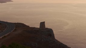 Torre Minervino watchtower and rugged coastline at sunrise, rocky cliffs, colorful sky over calm sea, Puglia, Italy. Aerial backward, copy space - Powered by Shutterstock - Get 15% off with code: PIKWIZARD15