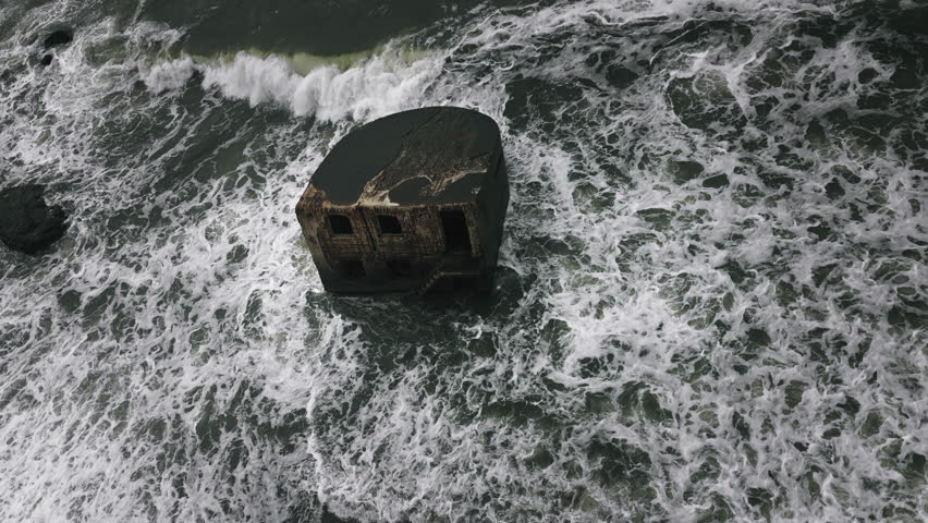 Aerial view of waves crashing against abandoned Soviet bunker ruins in Karosta Liepaja Latvia